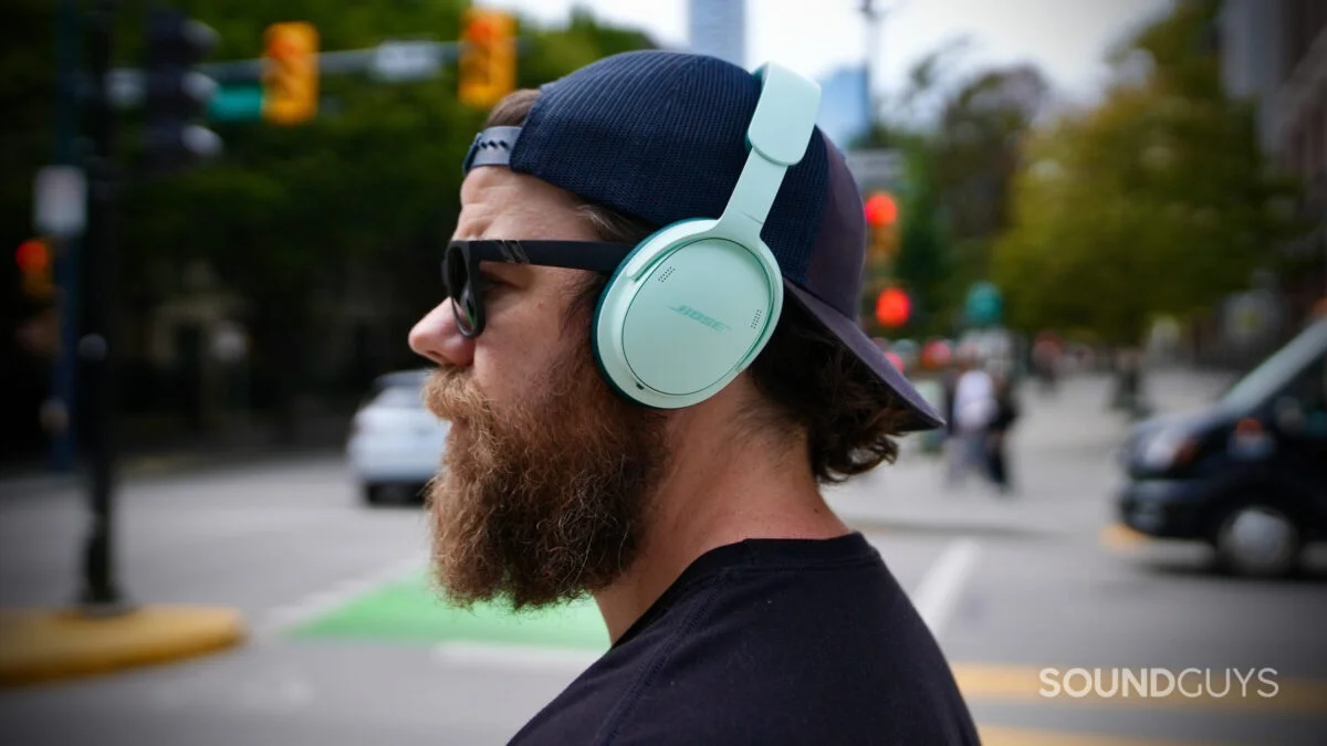 The Bose QuietComfort Headphones (2nd Gen) worn outdoors on a city street.