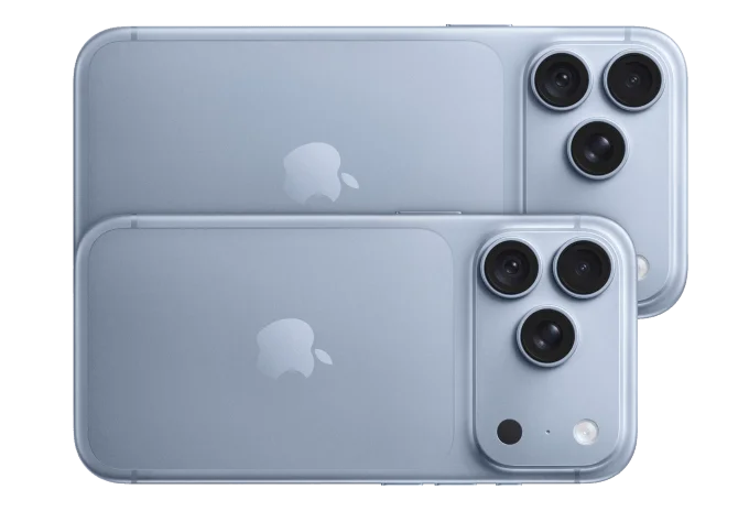 Two light blue iPhones lying on their sides, stacked and overlapping, showing their frosted-glass backs with Apple logos and triple-lens camera modules, flash, and sensor. The smaller phone sits in front of the larger one.