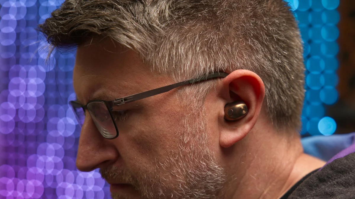 A photo of a man wearing the Sennheiser MOMENTUM True Wireless 5 earbuds.