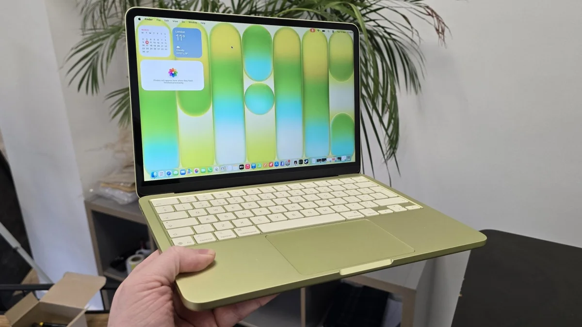 MacBook Neo laptop on a desk with plant in background