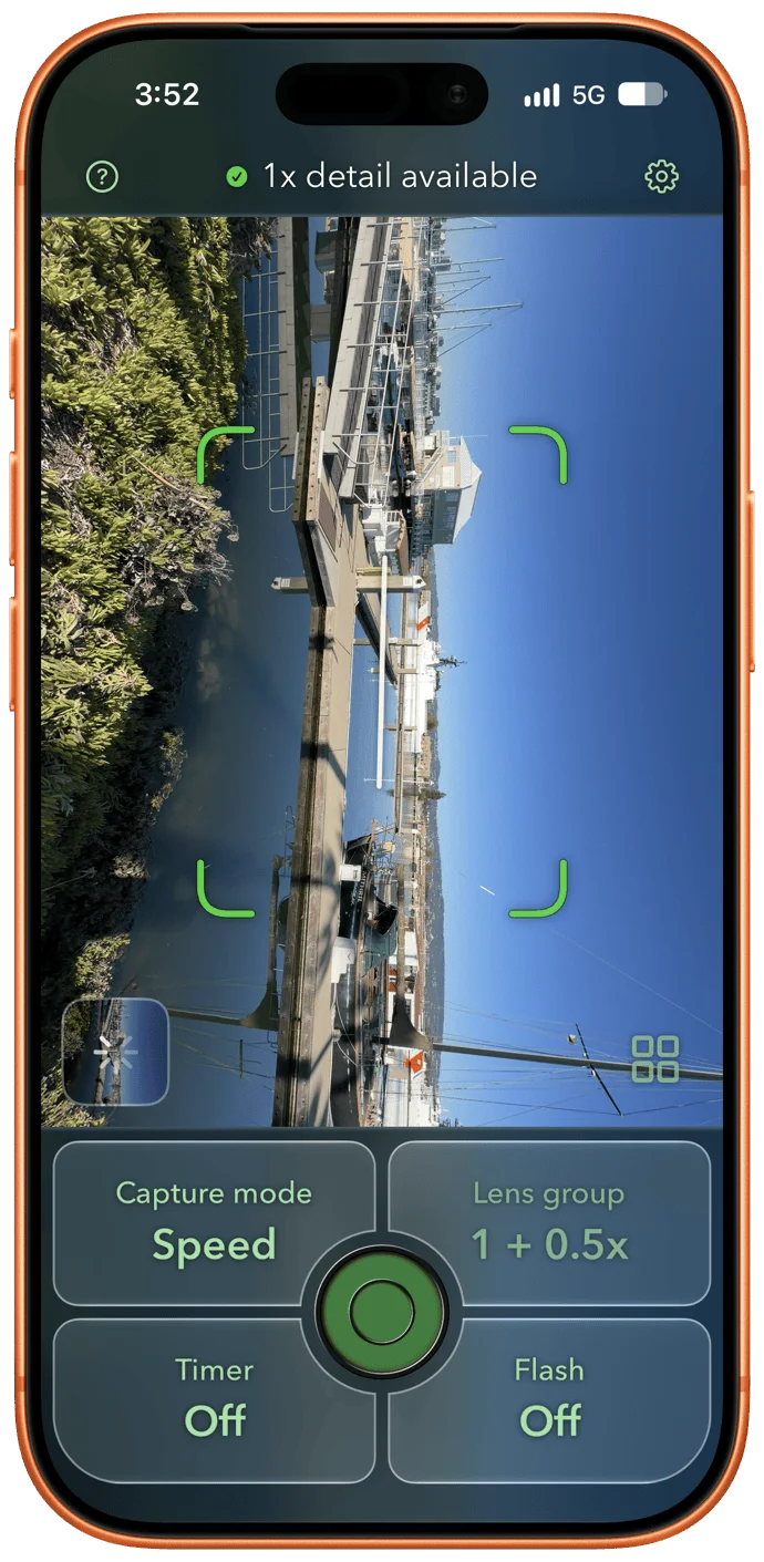 Screenshot of an iPhone camera app with a green-and-dark interface showing a sideways marina view with docks and boats. Top: "1x detail available." Controls: Capture mode Speed, Lens group 1 + 0.5x, Timer Off, Flash Off, and a central green shutter button.