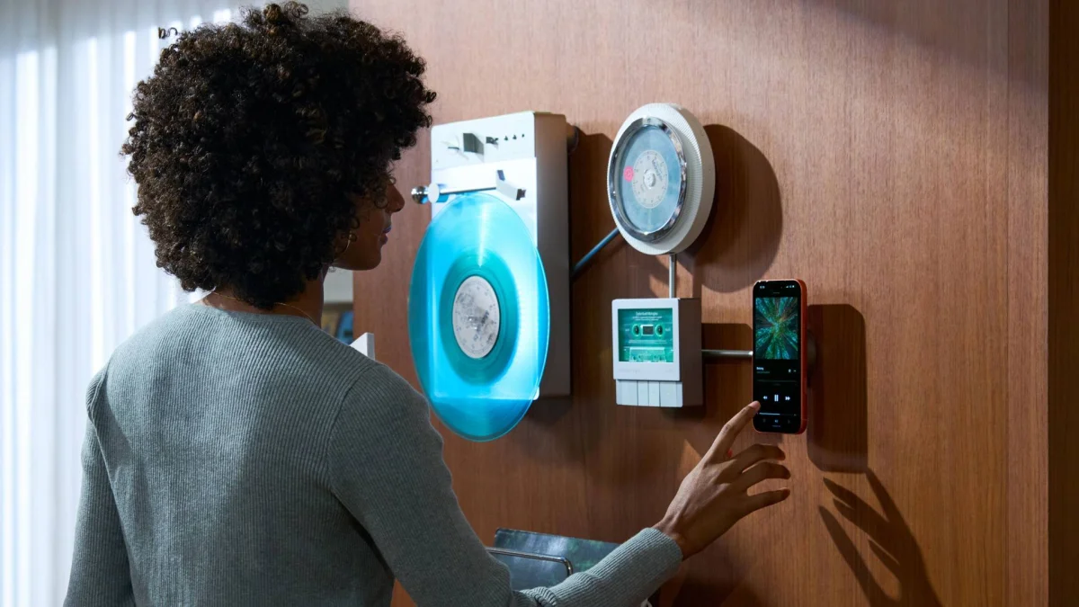 Trettire's Retro Ambient Audio System on a wall, with a woman pressing the smartphone.